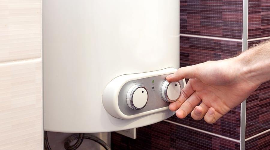 Homeowner adjusting the temperature on water heater
