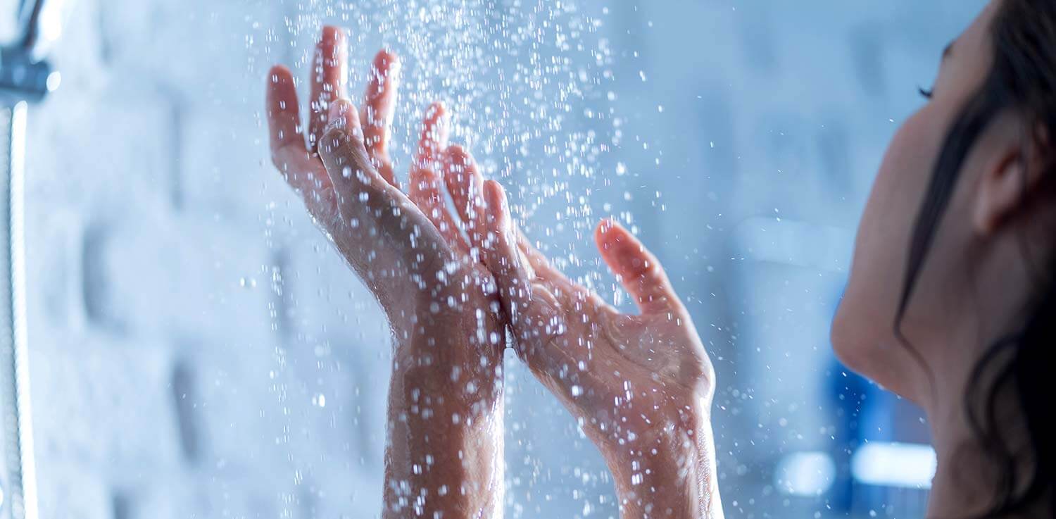 Woman’s hands in the shower.